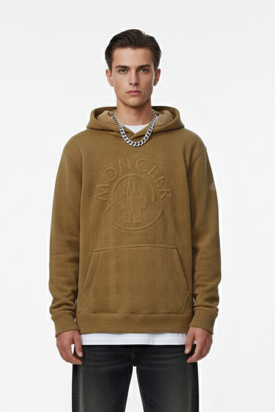 Man wearing a brown hoodie with branding on a white background