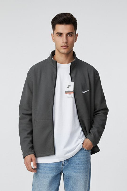 Man wearing a gray jacket, white t-shirt, and blue jeans on a white background