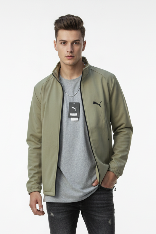 Man wearing a green jacket, gray t-shirt, and black jeans on a white background