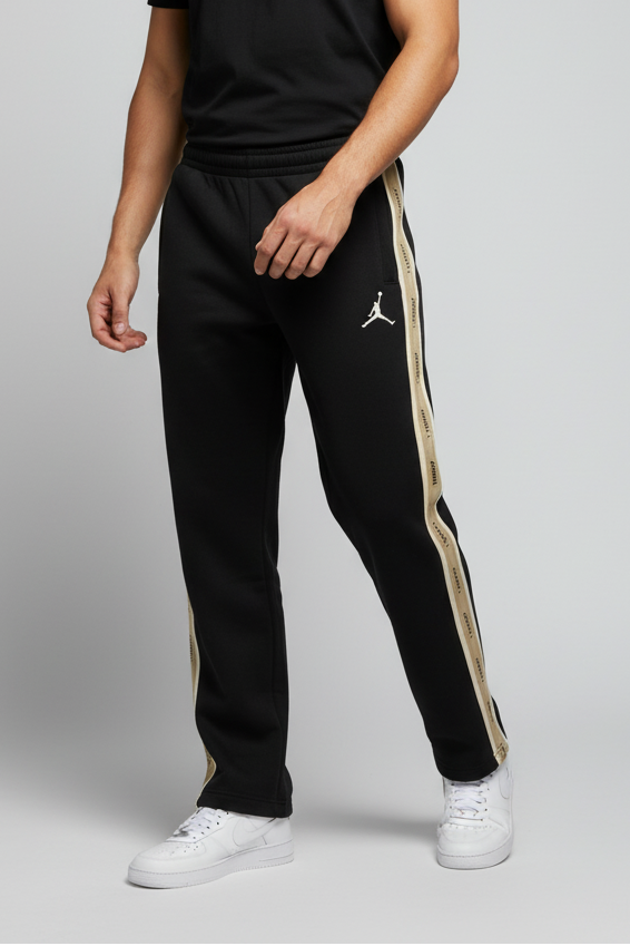 Man wearing a black t-shirt and black tracksuit with a logo on a gray background