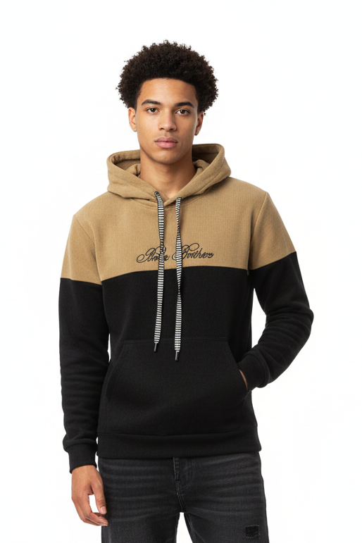 Person wearing a black and beige hoodie with ripped jeans on a white background